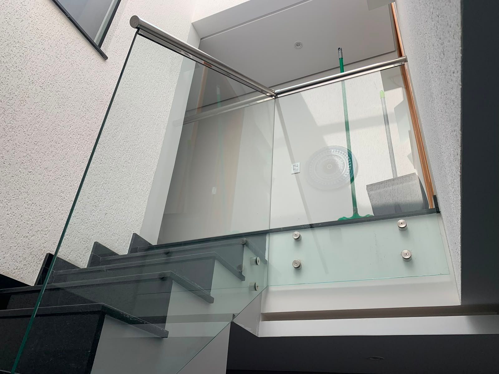Guarda-corpo de vidro com corrimão de inox em escada